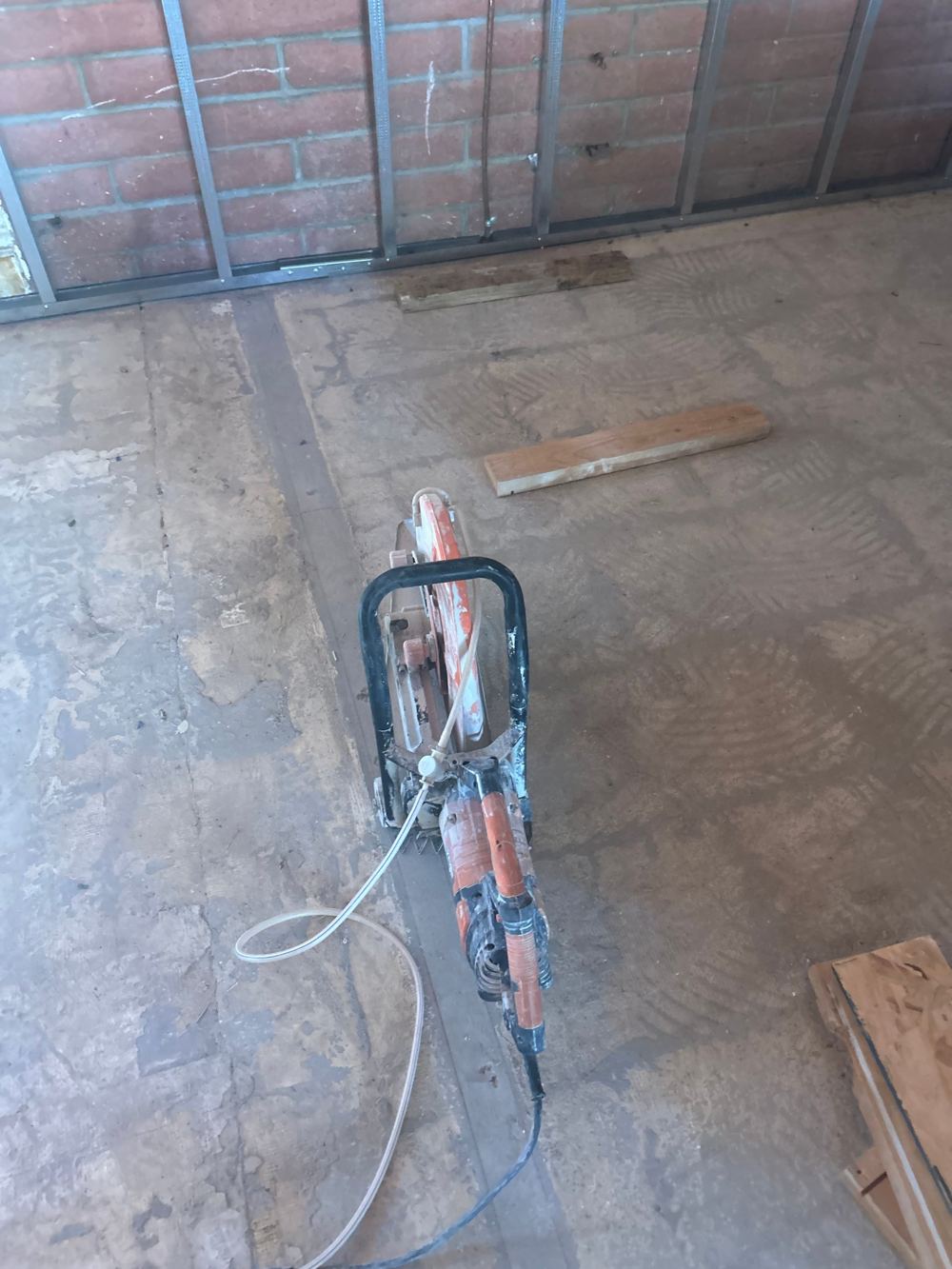 Handheld concrete saw on a straight cut line in an interior slab